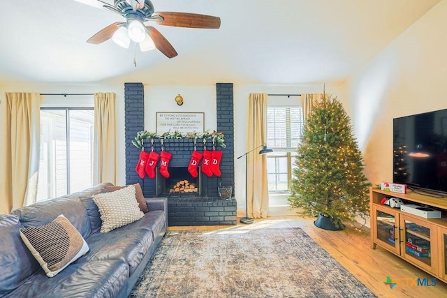 living room with ceiling fan, a fireplace, and hardwood / wood-style flooring