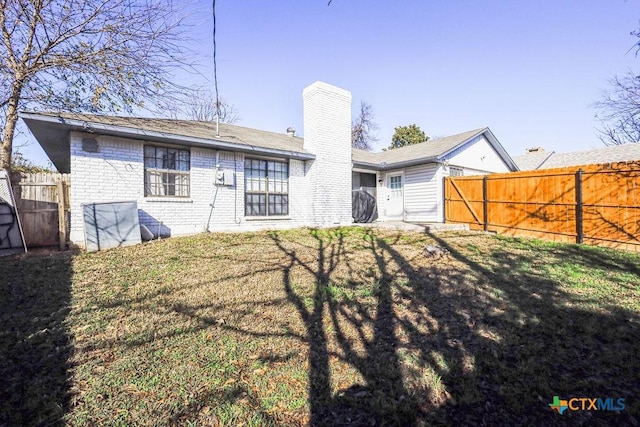 back of house featuring a lawn