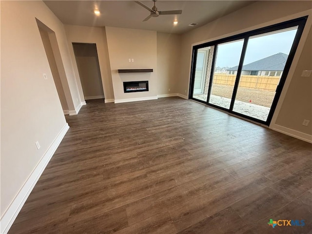 unfurnished living room featuring ceiling fan and dark hardwood / wood-style flooring