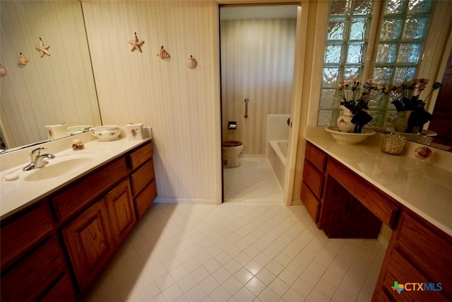 bathroom featuring tile patterned flooring, a bath, toilet, and vanity