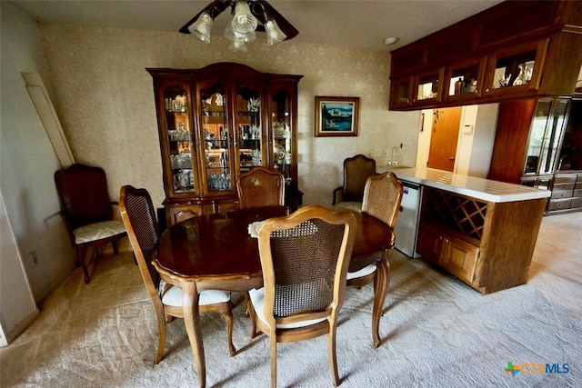 dining room featuring sink and light carpet