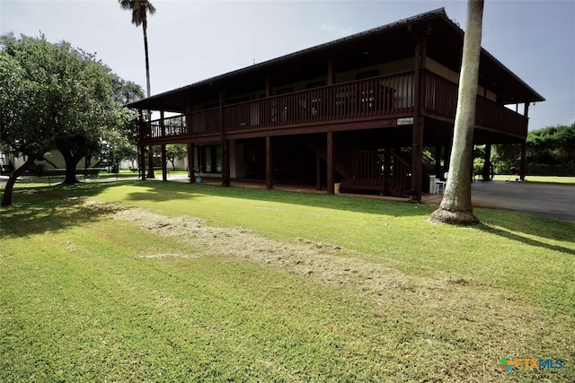 back of house with a lawn and a deck