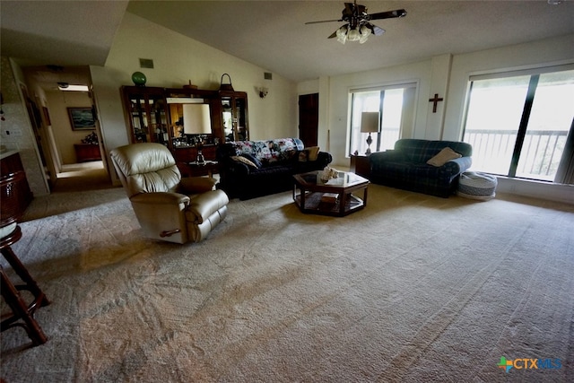 carpeted living room featuring ceiling fan and vaulted ceiling