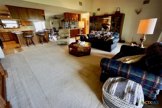 carpeted living room featuring ceiling fan