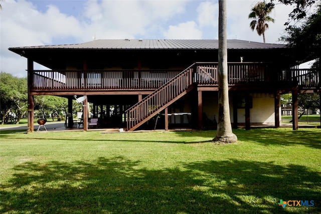 rear view of house with a lawn and a wooden deck