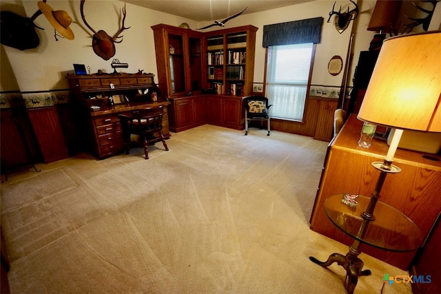 office area with wooden walls and light carpet