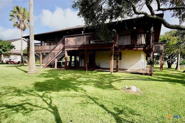 rear view of house featuring a yard and a wooden deck