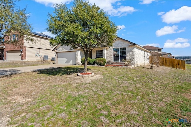 view of front of property with driveway, a garage, stone siding, fence, and a front lawn