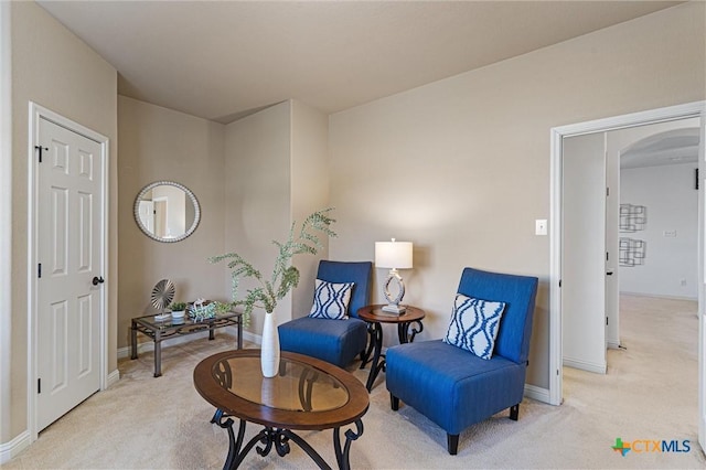 2474 Santa Barbara Loop, Round Rock, TX 78665 - living area featuring arched walkways, light carpet, and baseboards
