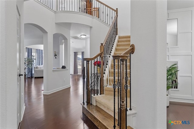2474 Santa Barbara Loop, Round Rock, TX 78665 - entrance foyer featuring wood finished floors, a towering ceiling, stairs, arched walkways, and baseboards