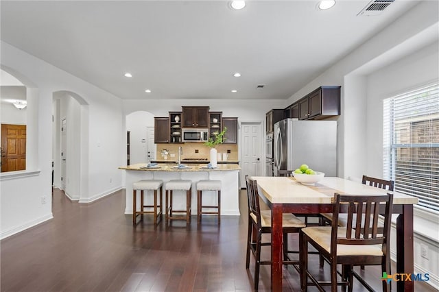 2474 Santa Barbara Loop, Round Rock, TX 78665 - dining area featuring arched walkways, recessed lighting, dark wood-type flooring, and baseboards