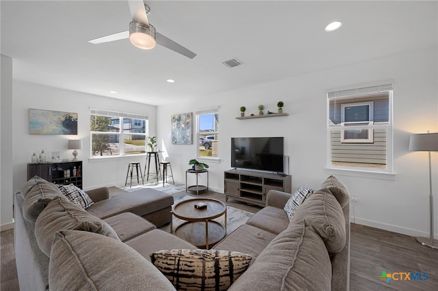 living area featuring baseboards, visible vents, wood finished floors, and recessed lighting