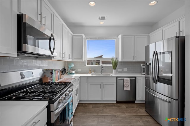 kitchen with visible vents, white cabinets, appliances with stainless steel finishes, light countertops, and a sink