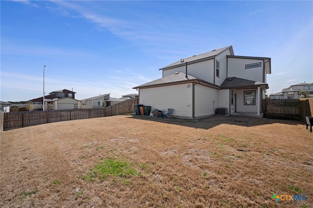 back of property with a lawn, cooling unit, and a fenced backyard