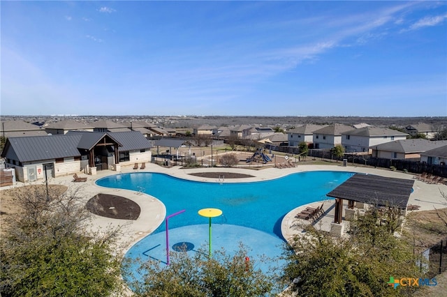 community pool featuring a residential view, fence, playground community, and a patio