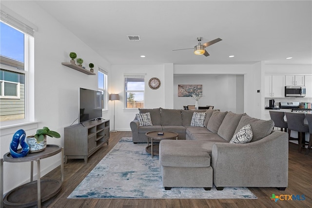 living area featuring visible vents, dark wood-type flooring, and recessed lighting