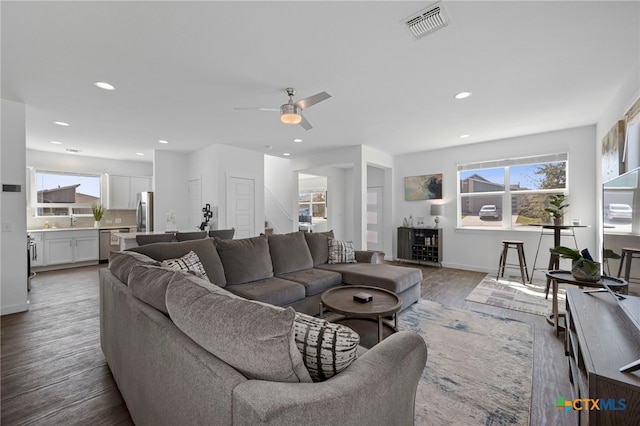 living room with a wealth of natural light, visible vents, light wood-style flooring, and recessed lighting