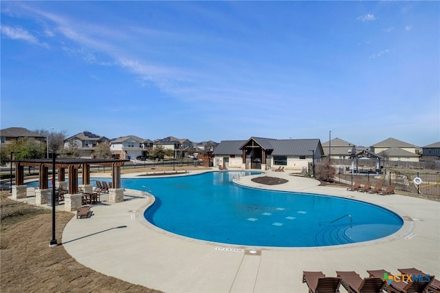 community pool featuring a patio area, a residential view, fence, and a gazebo