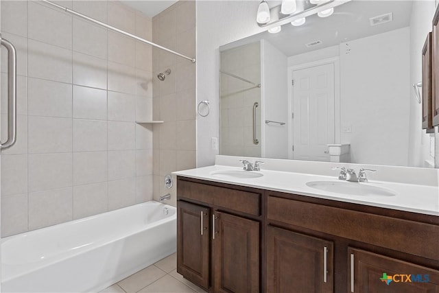 bathroom featuring tile patterned flooring, vanity, and tiled shower / bath combo