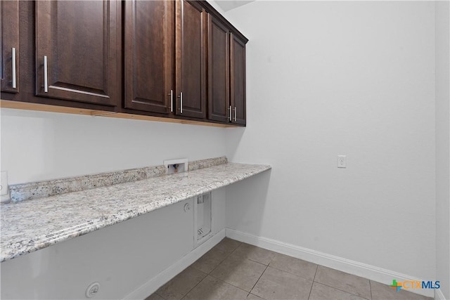 laundry area featuring cabinets, light tile patterned floors, and hookup for a washing machine