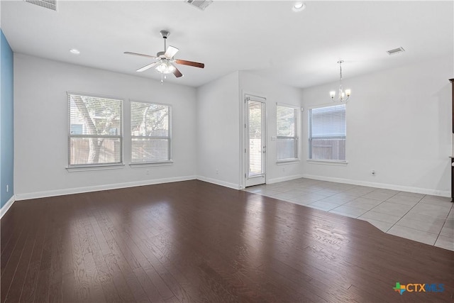 unfurnished living room featuring light tile patterned floors and ceiling fan with notable chandelier