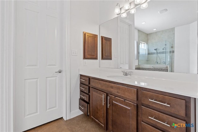 bathroom featuring tile patterned flooring, vanity, and walk in shower