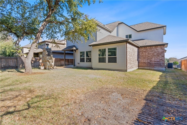 back of property featuring central AC unit and a lawn