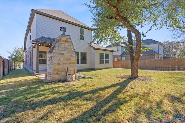 rear view of house featuring a yard