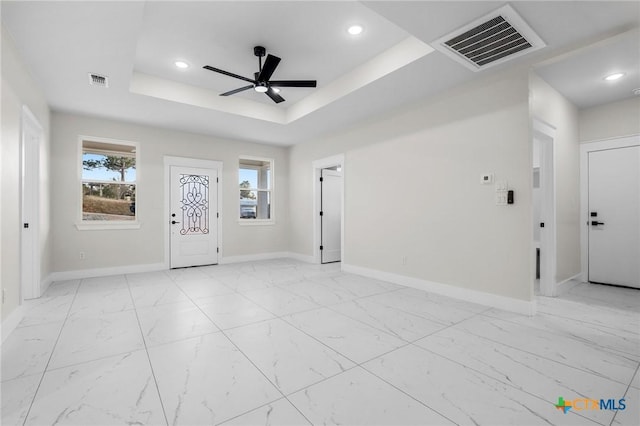 entrance foyer with a raised ceiling, a wealth of natural light, and ceiling fan