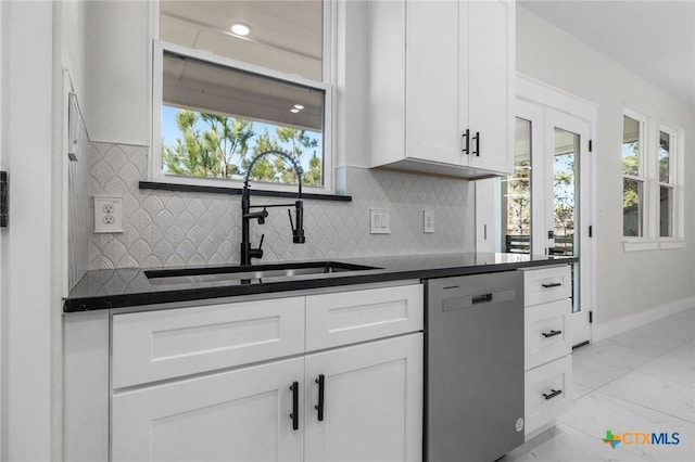 kitchen featuring sink, stainless steel dishwasher, white cabinets, and decorative backsplash