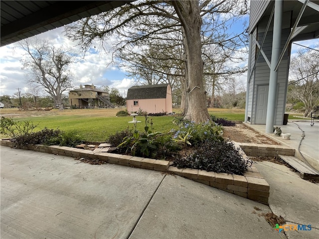 view of yard featuring a patio area and a storage shed