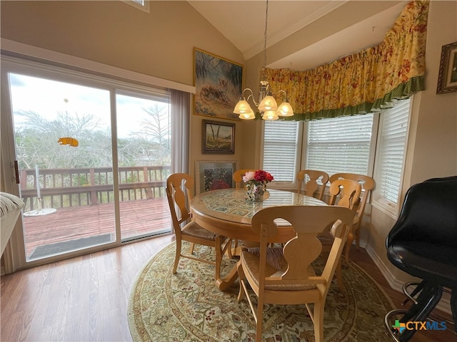 dining area with a chandelier, vaulted ceiling, and hardwood / wood-style flooring