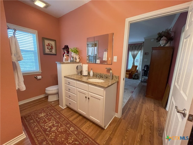 bathroom with hardwood / wood-style flooring, vanity, and toilet