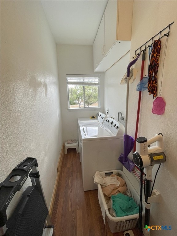 laundry room with dark hardwood / wood-style flooring, cabinets, and independent washer and dryer