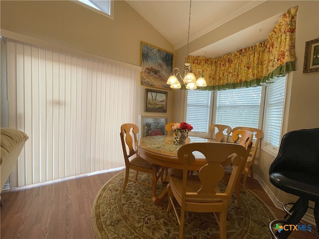 dining area with hardwood / wood-style floors, a notable chandelier, and vaulted ceiling