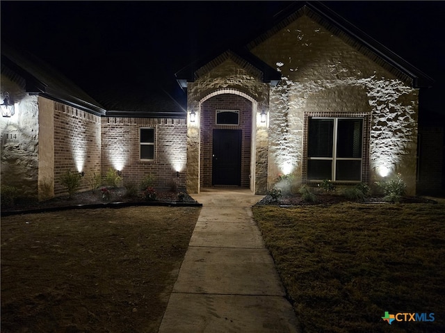 view of exterior entry at twilight