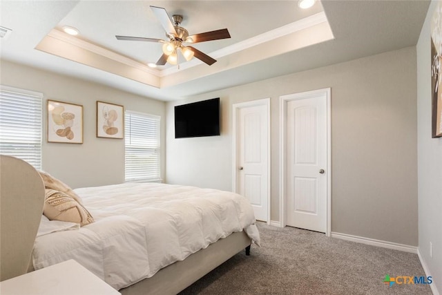 bedroom featuring a tray ceiling, carpet, visible vents, ornamental molding, and baseboards