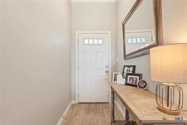 doorway with baseboards and light wood-style floors