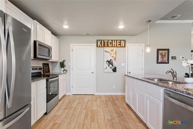 kitchen with visible vents, white cabinets, appliances with stainless steel finishes, light wood-type flooring, and a sink