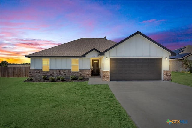 view of front of property featuring a garage, a front lawn, brick siding, and board and batten siding