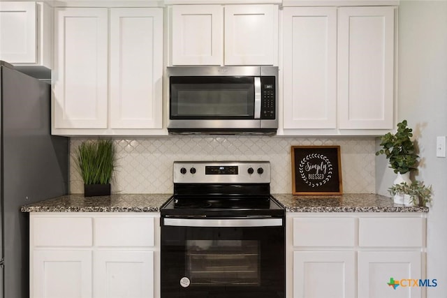 kitchen featuring tasteful backsplash, white cabinetry, dark stone counters, and stainless steel appliances