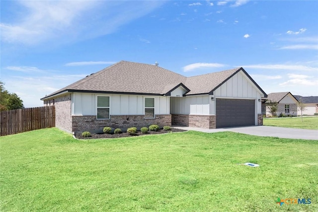 view of front of home featuring a garage, fence, board and batten siding, and a front yard