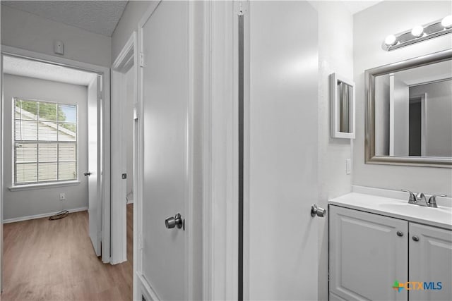 1709 Bobby Lee Dr, Killeen, TX 76549 - bathroom featuring wood finished floors, vanity, a textured ceiling, and baseboards