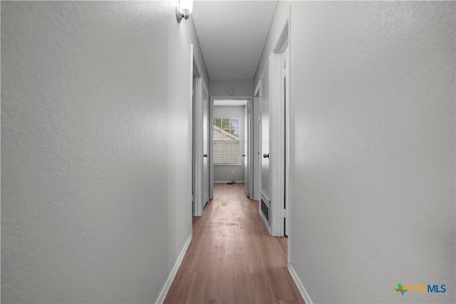1709 Bobby Lee Dr, Killeen, TX 76549 - hallway featuring baseboards, wood finished floors, and a textured wall