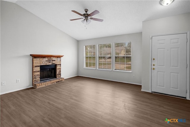 1709 Bobby Lee Dr, Killeen, TX 76549 - unfurnished living room with ceiling fan, wood finished floors, lofted ceiling, a brick fireplace, and baseboards