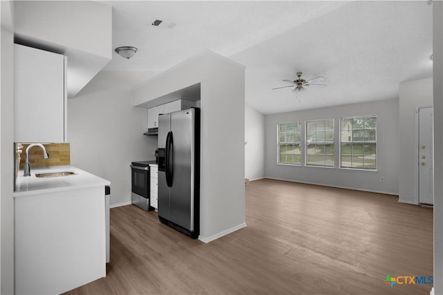 1709 Bobby Lee Dr, Killeen, TX 76549 - kitchen featuring stainless steel appliances, a sink, light wood-type flooring, white cabinets, and decorative backsplash