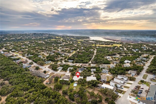 aerial view at dusk featuring a water view