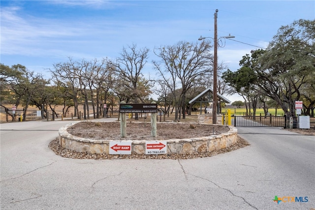 exterior space with aphalt driveway, fence, and a gate