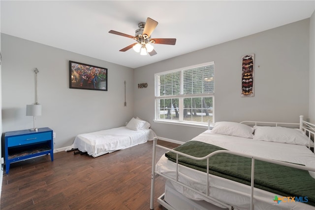 bedroom with a ceiling fan, baseboards, and wood finished floors