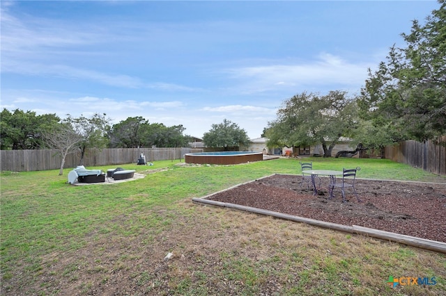 view of yard with an outdoor fire pit, a fenced in pool, and a fenced backyard